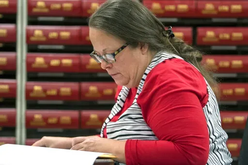 In this Nov. 6, 2018, file photo, Kim Davis, the county clerk for Rowan County in Kentucky, works with the county election board on Election Day, in Morehead, Ky.  A federal judge has ruled, Friday, March 18, 2022,  that the former Kentucky clerk violated the constitutional rights of two same-sex couples after she wouldn't issue them marriage licenses — a refusal that sparked international attention and briefly landed her in jail in 2015.  (AP Photo/John Flavell, File)