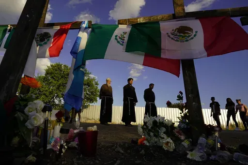 People visit a makeshift memorial honoring the victims and survivors of a human smuggling tragedy, where dozens of migrants were found in an airless tractor-trailer rig, in San Antonio, July 6, 2022. (AP Photo/Eric Gay, File)