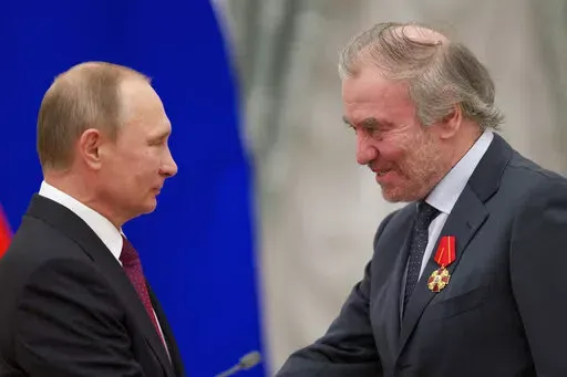 Russian President Vladimir Putin, left, presents a medal to then Mariinsky Theatre's Artistic Director Valery Gergiev, during an awarding ceremony in Moscow's Kremlin, Russia, Thursday, Sept. 22, 2016. Munich's mayor says Valery Gergiev has been fired as chief conductor of the Munich Philharmonic because of his support for Russian President Vladimir Putin and for not rejecting the invasion of Ukraine. (AP Photo/Ivan Sekretarev, pool,file)