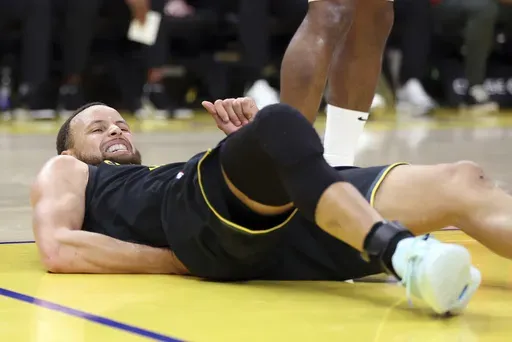 Golden State Warriors' Stephen Curry grimaces in pain after a rough landing in the 3rd quarter against Toronto Raptors during NBA game at Chase Center in San Francisco on Thursday, March 20, 2025.(Scott Strazzante/San Francisco Chronicle via AP)