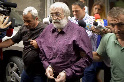 Romanian guru Gregorian Bivolaru is escorted to a vehicle, after a hearing at the Romanian Police headquarters in Bucharest, Romania, Wednesday, Aug. 24, 2016. French authorities arrested the leader of a multinational tantric yoga organization Tuesday Nov. 28, 2023 on suspicion of indoctrinating female followers for sexual exploitation. The Romanian guru at the heart of the Atman Yoga Federation was detained during a massive morning police operation across the Paris region. (AP Photo/Marian Ilie