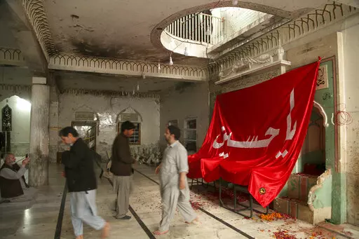 People visit Kusha Kisaldar Shiite Mosque, the site of March 4 suicide bombing, to offer prays for bombing victims, in Peshawar, Pakistan, Wednesday, March 9, 2022. In northwest Pakistan the remains of an IS suicide bomber are still visible on the once ornate walls of a mosque where last month more than 63 worshippers died as they knelt in prayer. The bomber, an Afghan identified by IS as Julaybib al-Kabuli, was from the capital Kabul. (AP Photo/Muhammad Sajjad)