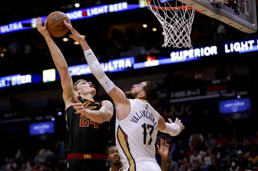 New Orleans Pelicans center Jonas Valanciunas (17) blocks a shot attempt by Cleveland Cavaliers forward Lauri Markkanen (24) during the first quarter of an NBA basketball game in New Orleans, Tuesday, Dec. 28, 2021. (AP Photo/Derick Hingle)