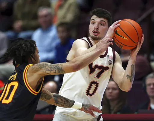 Virginia Tech's Hunter Cattoor (0) looks to pass while guarded by Grambling State's Virshon Cotton (00) in the first half of an NCAA college basketball game in Blacksburg, Va., Saturday, Dec. 17 2022. (Matt Gentry/The Roanoke Times via AP)