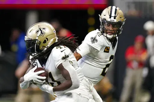 New Orleans Saints quarterback Jameis Winston (2) hands the ball off to New Orleans Saints running back Alvin Kamara (41) during the first half of an NFL football game, Sunday, Sept. 11, 2022, in Atlanta. (AP Photo/Brynn Anderson)