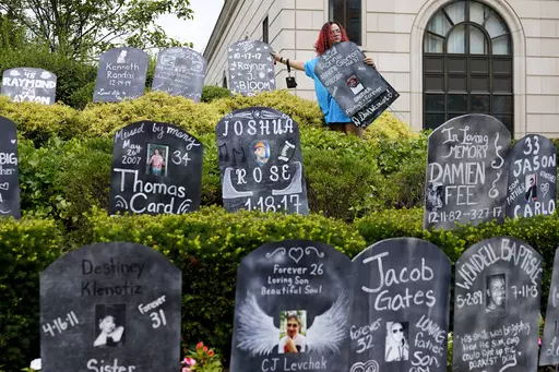 Jayde Newton helps to set up cardboard gravestones with the names of victims of opioid abuse outside the courthouse where the Purdue Pharma bankruptcy is taking place in White Plains, N.Y., on Aug. 9, 2021. A three-judge panel of the 2nd U.S. Circuit Court of Appeals in New York on Tuesday, May 30 overturned a lower court’s 2021 ruling that found bankruptcy courts did not have the authority to protect members of the Sackler family who own the company and who have not filed for bankruptcy prote