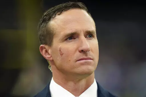 Former New Orleans Saints quarterback Drew Brees, now a TV analyst, talks on the field before an NFL football game against the Buffalo Bills in New Orleans, on Nov. 25, 2021. Brees is officially done at NBC Sports after one year. NBC Sports president Pete Bevacqua said in a phone interview with the Associated Press that Brees will not be a part of the network’s NFL and Notre Dame coverage this year.(AP Photo/Derick Hingle, File)