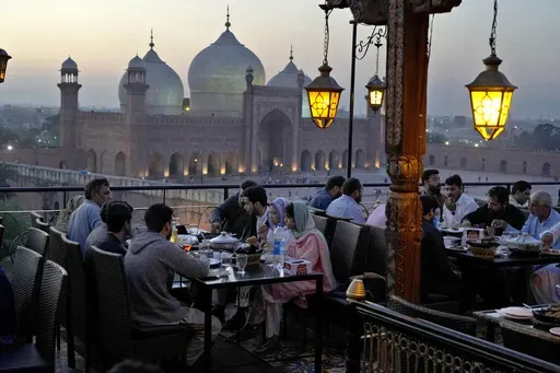 People break their fasts during the Muslim's holy fasting month of Ramadan, at a rooftop restaurant near the historical Badshahi mosque, in background, in Lahore, Pakistan, March 15, 2024. (AP Photo/K.M. Chaudary, File)