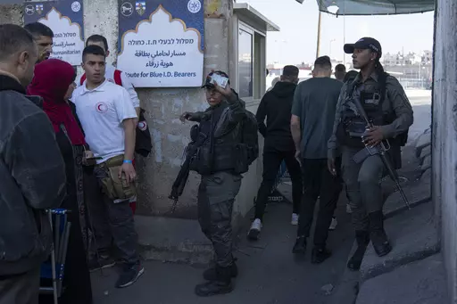 Israeli border police officers check identification cards of Palestinians while they try to cross from the occupied West Bank into Jerusalem, to pray during the holiest night of Ramadan, Laylat al-Qadr, or the "Night of Destiny," when Muslims believe that the Quran was revealed to the Prophet Mohammad, in the Al Aqsa mosque compound, at the Israeli military Qalandiya checkpoint, near Ramallah, Monday, April 17, 2023. Hundreds of thousands of Palestinians are barred from legally crossing into the