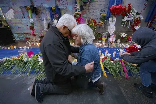 Long Island, New York residents Louis Tenedorio, left, and his wife, Cathy Tenedorio, embrace on by a memorial Bourbon Street and Canal Street in New Orleans, Saturday, Jan. 4, 2025, where their son, Matthew Tenedorio, was killed as one of the victims of the New Year's Day deadly truck attack and shooting. (AP Photo/Matthew Hinton)