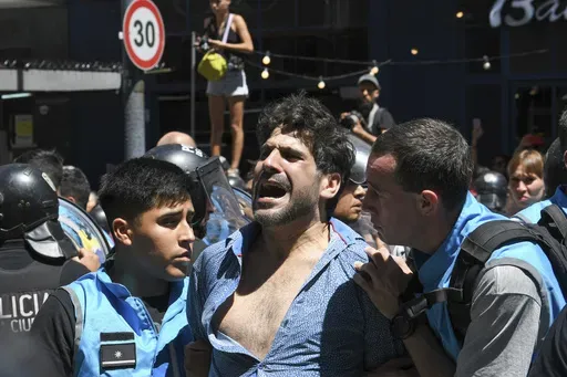 Police detain a protester for blocking the streets during an anti-government demonstration against the economic reforms of President Javier Milei in Buenos Aires, Argentina, Wednesday, Dec. 27, 2023. Milei's government has warned it will not allow protesters to block streets. (AP Photo/Gustavo Garello)