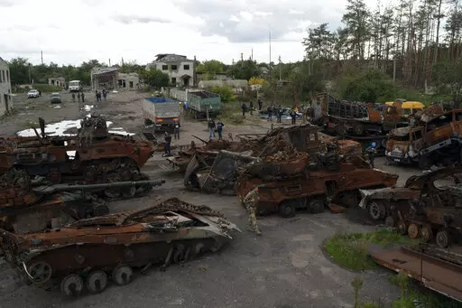 A Ukrainian serviceman and journalists walk between destroyed Russian equipment placed in an area at the recaptured town of Lyman, Ukraine, Wednesday, Oct. 5, 2022. (AP Photo/Leo Correa)