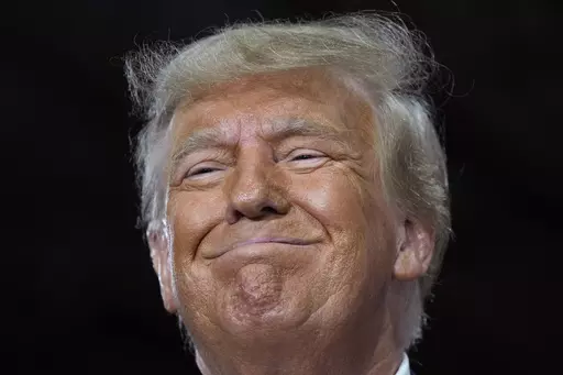 Former President Donald Trump speaks during a commit to caucus rally, Oct. 16, 2023, in Adel, Iowa. Trump is crushing his Republican presidential rivals in the contest to raise campaign cash, putting the other White House hopefuls in an unenviable position before the first votes are cast in January. (AP Photo/Charlie Neibergall)