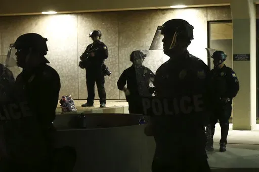 Phoenix Police stand in front of police headquarters on May 30, 2020, in Phoenix, waiting for protesters marching to protest the death of George Floyd. A controversial Arizona law restricting how the public can film police is facing its first legal challenge with a lawsuit filed by the ACLU. The group's Arizona chapter, joined by several Arizona news organizations, filed a petition Tuesday, Aug. 23, 2022, in federal court to stop the law. (AP Photo/Ross D. Franklin, File)