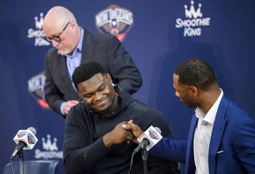New Orleans Pelicans forward Zion Williamson shakes hands with New Orleans Pelicans head coach Willie Green with New Orleans Pelicans vice president of basketball operations David Griffin standing in the background after talking to the media about signing his contract extension at the Dryades YMCA in New Orleans, Wednesday, July 6, 2022. (Max Becherer/The Times-Picayune/The New Orleans Advocate via AP)