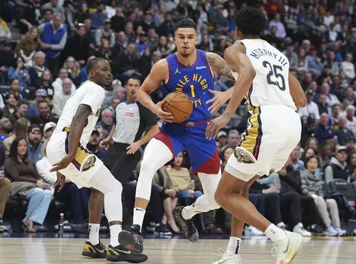 Denver Nuggets forward Michael Porter Jr., center, drives to the basket as New Orleans Pelicans guards Javonte Green, left, and Trey Murphy III, right, defend in the first half of an NBA basketball game Monday, Feb. 3, 2025, in Denver. (AP Photo/David Zalubowski)