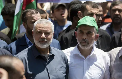 Head of the Hamas political bureau, Ismail Haniyeh, left, and Hamas leader in the Gaza Strip Yahya Sinwar attend a protest in Gaza City on June 26, 2019. (AP Photo/Khalil Hamra, File)