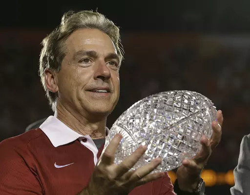 In this Jan. 7, 2013, file photo, Alabama head coach Nick Saban holds The Coaches Trophy after the BCS National Championship college football game against Notre Dame, in Miami. Nick Saban, the stern coach who won seven national championships and turned Alabama back into a national powerhouse that included six of those titles in just 17 seasons, is retiring, according to multiple reports, Wednesday, Jan. 10, 2024. (AP Photo/David J. Phillip, File)