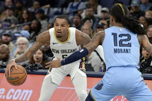 New Orleans Pelicans guard Dejounte Murray (5) handles the ball against Memphis Grizzlies guard Ja Morant (12) in the first half of an Emirates NBA Cup basketball game Friday, Nov. 29, 2024, in Memphis, Tenn. (AP Photo/Brandon Dill)