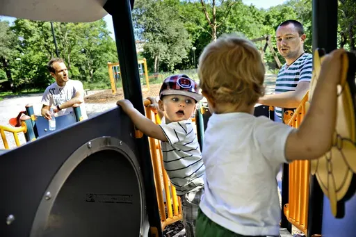 Henrik Holgersson, right, watches his son, Arvid, center with hat, play with Walter Johansson accompanied by his father Henrik Johansson at a playground in Stockholm, Sweden, Wednesday June 29, 2011. Fifty years after Sweden became the first country in the world to introduce paid parental leave for fathers, the Scandinavian country has launched a groundbreaking new law granting paid leave allowing grandparents and other legal guardians to care for a child. The law came into effect Monday, July 1