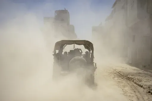 Israeli army vehicles transport a group of soldiers and journalists inside the southern Gaza Strip, Wednesday, July 3, 2024. The Israeli military invited reporters for a tour of Rafah, where the military has been operating since May 6. (AP Photo/Ohad Zwigenberg, Pool)
