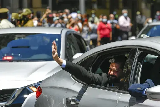 Chilean President-elect Gabriel Boric waves to supporters as he arrives to La Moneda presidential palace for a meeting with current President Sebastian Pinera in Santiago, Chile, Monday, Dec. 20, 2021. (AP Photo/Matias Delacroix)