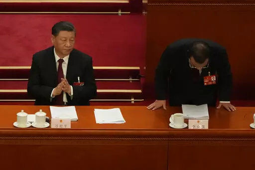 Chinese Premier Li Keqiang, right, bows after delivering his state of the nation address during the opening session of China's National People's Congress (NPC) at the Great Hall of the People in Beijing, Sunday, March 5, 2023. After a decade in Chinese President Xi Jinping's shadow, Li Keqiang is taking his final bow as the country's premier, marking a shift away from the skilled technocrats who have helped steer the world's second-biggest economy in favor of officials known mainly for their unq