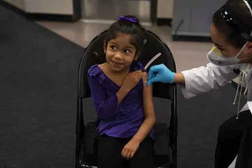 Elsa Estrada, 6, smiles at her mother as pharmacist Sylvia Uong applies an alcohol swab to her arm before administering the Pfizer COVID-19 vaccine at a pediatric vaccine clinic for children ages 5 to 11 set up at Willard Intermediate School in Santa Ana, Calif., Nov. 9, 2021. As of Tuesday, Jan. 11, 2022, just over 17% of children in the U.S. ages 5 to 11 were fully vaccinated, more than two months after shots for them became available. (AP Photo/Jae C. Hong, File)