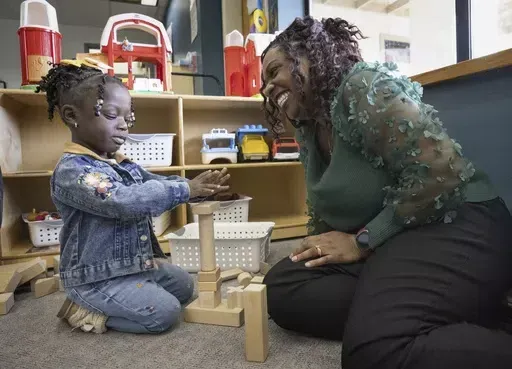 Zaneta Billyzone-Jatta smiles at her two-year-old daughter Zakiah Jatta in her classroom at Akin's Early Learning Center in Auburn Tuesday, March 26, 2024 in Auburn, Wash.. Zakiah is enrolled in Washington state's Early ECEAP (Early Childhood Education and Assistance Program). (Ellen M. Banner/The Seattle Times via AP)