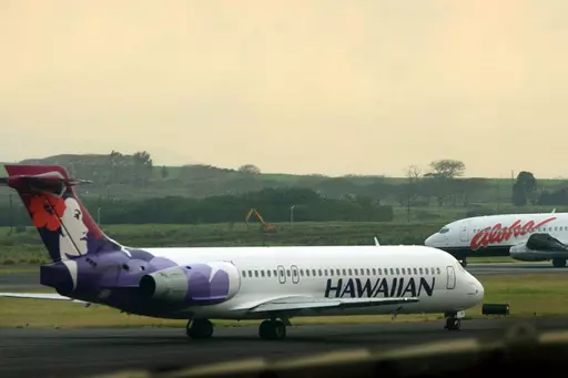 An Hawaiian Airlines plane taxis for position at Kahalui, Hawaii, on the island of Maui, March 24, 2005. Alaska Air Group said Sunday, Dec. 3, 2023, that it agreed to buy Hawaiian Airlines in a $1 billion deal. (AP Photo/Lucy Pemoni, File)