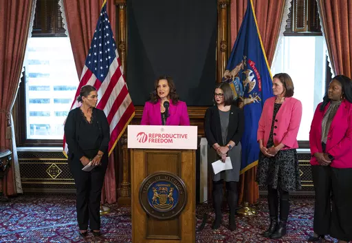 Michigan Gov. Gretchen Whitmer talks with the press before signing the final bill in the Reproductive Health Act on Monday, Dec. 11, 2023, at the Michigan State Capitol building in Lansing, Mich. The bill repeals Michigan's ban on insurance coverage for abortion without the purchase of a separate rider and implements other protections for doctors and patients. (Ryan Garza/Detroit Free Press via AP)
