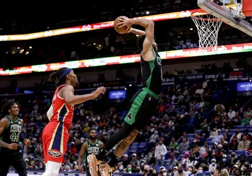 Boston Celtics forward Jayson Tatum (0) dunks past New Orleans Pelicans guard Devonte' Graham (4) in the fourth quarter of an NBA basketball game in New Orleans, Saturday, Jan. 29, 2022. (AP Photo/Derick Hingle)