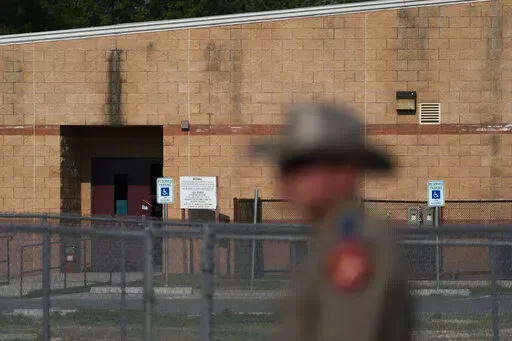 A back door at Robb Elementary School, where a gunman entered through to get into a classroom in last week's shooting, is seen in the distance in Uvalde, Texas, Monday, May 30, 2022. (AP Photo/Jae C. Hong)