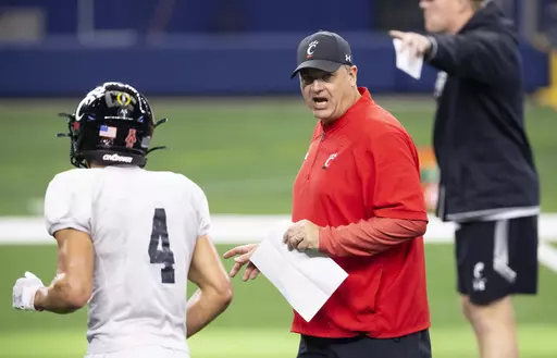 Cincinnati offensive coordinator Mike Denbrock coaches his players during practice for the Cotton Bowl NCAA football game, Dec. 27, 2021, in Arlington, Texas. Denbrock is back for a third coaching stint at Notre Dame, this time as offensive coordinator. The school announced Denbrock's hiring on Wednesday, Dec. 27, 2023. (AP Photo/Brandon Wade, File)