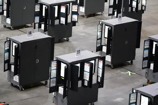 Voting machines fill the floor for early voting at State Farm Arena on Monday, Oct. 12, 2020, in Atlanta. In an advisory sent to state election officials, and obtained by The Associated Press in advance of its expected release on Friday, June 3, 2022, the nation’s leading cybersecurity agency says that electronic voting machines from a leading vendor used in at least 16 states have software vulnerabilities. The U.S. Cybersecurity and Infrastructure Agency, or CISA, said there is no evidence th
