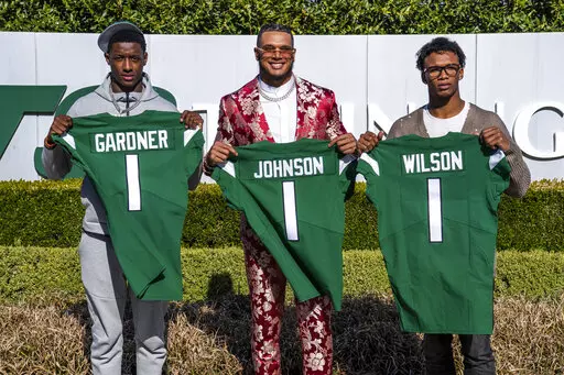 From left to right, Ahmad Gardner, Jermaine Johnson and Garrett Wilson pose for a portrait while holding New York Jets jerseys Friday, April 29, 2022, in Florham Park, N.J. (AP Photo/Brittainy Newman)