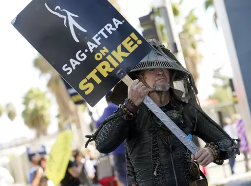 SAG-AFTRA member Bruce D. Mitchell participates in a post apocalyptic-themed picket line outside Netflix studios, Nov. 8, 2023, in Los Angeles. Hollywood’s actors have voted to ratify the deal with studios that ended their strike after nearly four months, leaders announced Tuesday, Dec. 5, 2023. (AP Photo/Chris Pizzello, File)