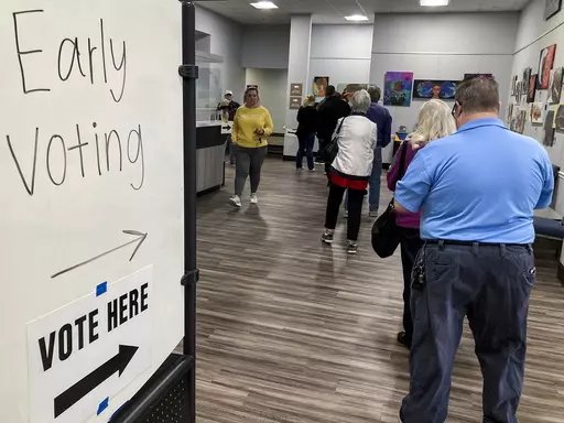People wait in line to early vote for the U.S. Senate runoff election in Georgia between Sen. Raphael Warnock and challenger Herschel Walker, on Nov. 28, 2022, in Kennesaw, Ga., near Atlanta. After years of criticizing mail voting and trying to ban so-called "ballot harvesting," Republicans are reversing course. They are poised to launch aggressive get-out-the-vote campaigns for 2024 that employ just those strategies.(AP Photo/Mike Stewart, File)