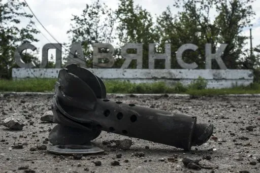 A part of the mortar shell is seen in front of a sign that reads 'Slovyansk', after heavy fighting between pro-Russian fighters and Ukrainian government troops just outside Slovyansk, eastern Ukraine, Wednesday, July 9, 2014. The eastern Ukrainian city of Slovyansk was occupied by pro-Russian separatists for months in 2014. Now its people are preparing to defend their community again as the fighting draws closer and invites a major battle. Slovyansk is a city of splintered loyalties, with some r