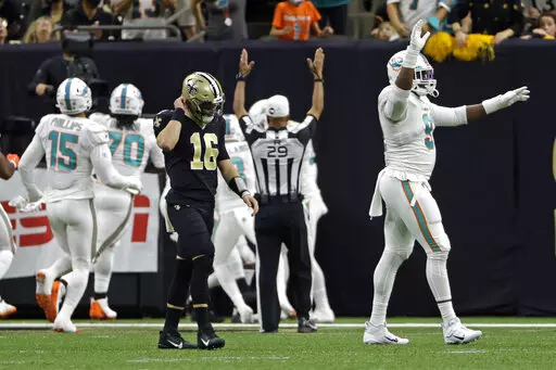 New Orleans Saints quarterback Ian Book (16) walks back to the bench after throwing an interception which was returned for a touchdown by Miami Dolphins' Nik Needham during the first half of an NFL football game Monday, Dec. 27, 2021, in New Orleans. (AP Photo/Derick Hingle)