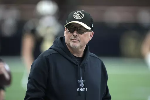 New Orleans Saints offensive coordinator Pete Carmichael Jr. is seen before the start of an NFL football game between the New York Giants and New Orleans Saints Sunday, Dec. 17, 2023, in New Orleans. The New Orleans Saints have fired offensive coordinator Pete Carmichael Jr. along with senior offensive assistant Bob Bicknell and receivers coach Kodi Burns. Saints coach Dennis Allen said in an announcement made Tuesday, Jan. 16, 2024, that the changes were necessary to move forward.(AP Photo/Gera