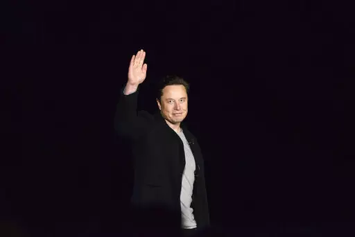 Elon Musk waves while providing an update on SpaceX's Starship, Thursday, Feb. 10, 2022, near Brownsville, Texas. In April 2022, a group of Tesla shareholders suing Musk over some 2018 tweets about taking the company private is asking a federal judge to order him to stop commenting on the case. (Miguel Roberts/The Brownsville Herald via AP, File)