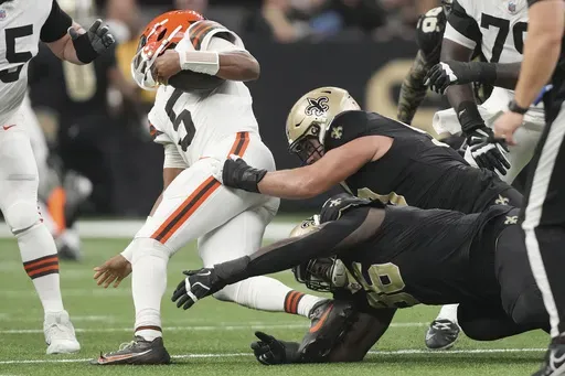 Cleveland Browns quarterback Jameis Winston (5) is sacked by New Orleans Saints defensive end Carl Granderson (96) and defensive tackle Bryan Bresee, right, in the first half of an NFL football game in New Orleans, Sunday, Nov. 17, 2024. (AP Photo/Gerald Herbert)