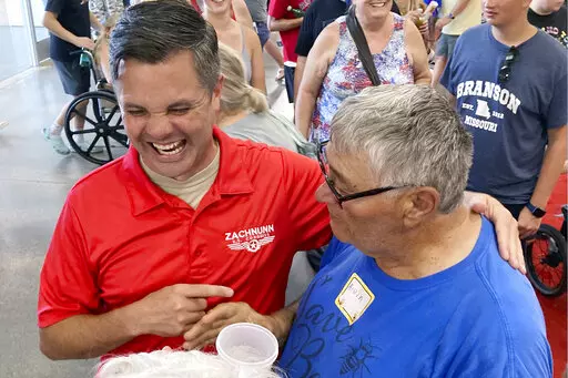 Iowa Republican candidate for Congress Zach Nunn, left, laughs while talking with Arvin Foell of Kelley, Iowa, during an appearance at the Iowa State Fair, in Des Moines, Iowa, August 12, 2022. Nunn is among more than a dozen strict abortion opponents running in competitive House, Senate and governor races working to soften his profile in light of increased enthusiasm among Democratic voters since the June U.S. Supreme Court decision reversing a federal right to abortion. (AP Photo/Thomas Beaumo
