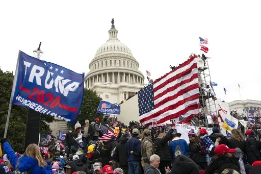 Violent insurrectionists loyal to President Donald Trump stand outside the U.S. Capitol in Washington on Jan. 6, 2021. The public hearings of the House committee investigating the insurrection pose a challenge to Democrats seeking to maintain narrow control of Congress. (AP Photo/Jose Luis Magana, File)
