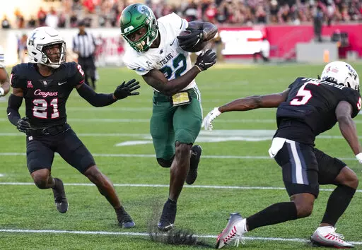 Tulane running back Tyjae Spears (22) cuts back between Houston defensive backs Abdul-Lateef Audu (21) and Hasaan Hypolite (5) on a reception for a first down during the second quarter of an NCAA college football game Friday, Sept. 30, 2022, in Houston. (Brett Coomer/Houston Chronicle via AP)