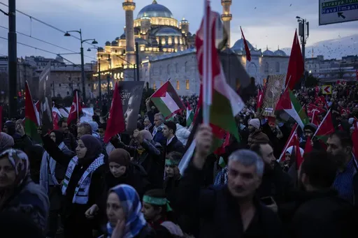 People demonstrate next to Yeni Cami (New Mosque) to show solidarity with Palestinians amid the ongoing war in Gaza, in Istanbul, Turkey, Monday, Jan. 1, 2024. Tens of thousands gathered in Istanbul to rally against the war in Israel on the first day of the new year. (AP Photo/Francisco Seco)