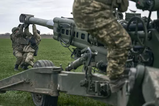 Ukrainian soldiers prepare a U.S.-supplied M777 howitzer to fire at Russian positions in Kherson region, Ukraine, Jan. 9, 2023. A rapidly expanding group of U.S. and allied troops and contractors are using phones and tablets to communicate in encrypted chat rooms to provide real-time maintenance advice to Ukrainian troops on the battlefield. As the U.S. and other allies provide a growing number of increasingly complex and high-tech weapons, the maintenance demands are expanding. (AP Photo/Libkos