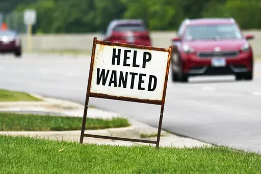 A help wanted sign is displayed at a gas station in Mount Prospect, Ill., Tuesday, July 27, 2021.  Fewer Americans applied for unemployment benefits last week as layoffs remain at historically low levels.  Jobless claims fell by 5,000 to 166,000 for the week ending April 2, 2022 the Labor Department reported Thursday.  (AP Photo/Nam Y. Huh)