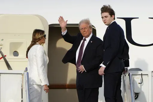 President-elect Donald Trump, standing with Melania and Barron Trump, waves as they board an Air Force Special Mission airplane at Palm Beach International Airport Saturday, Jan. 18, 2025 in West Palm Beach, Fla., en route to Washington. (AP Photo/Lynne Sladky)
